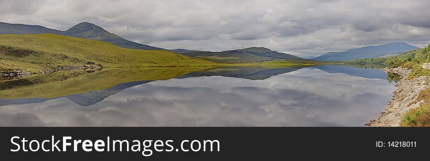 A nameless little lake in the Scottish Highlands reflecting the lonely moodiness of a grey day. A nameless little lake in the Scottish Highlands reflecting the lonely moodiness of a grey day