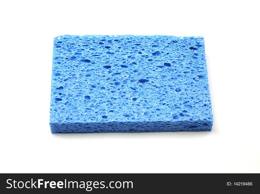 A blue square sponge on a white background. A blue square sponge on a white background.