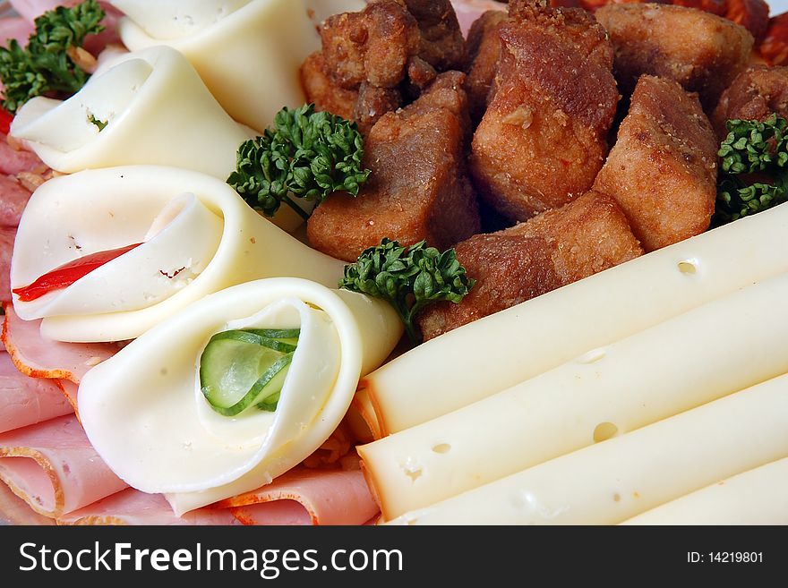 Salami and cheese rolls with vegetables on a plate