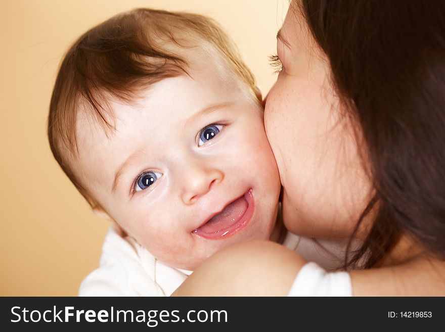 Laughing baby boy in mothers arm; closeup faces