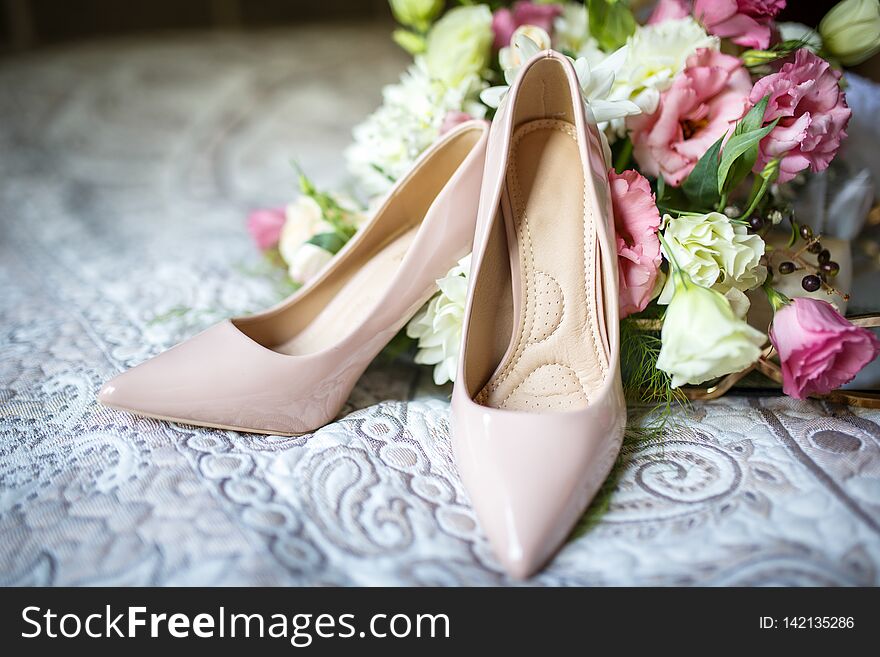 Wedding shoes with bouquet on bed