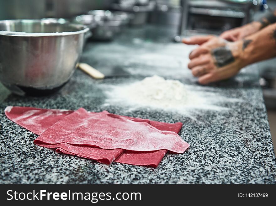 Traditional italian food. Close up photo of colorful dough for homemade pasta lying on the kitchen table. Food concept