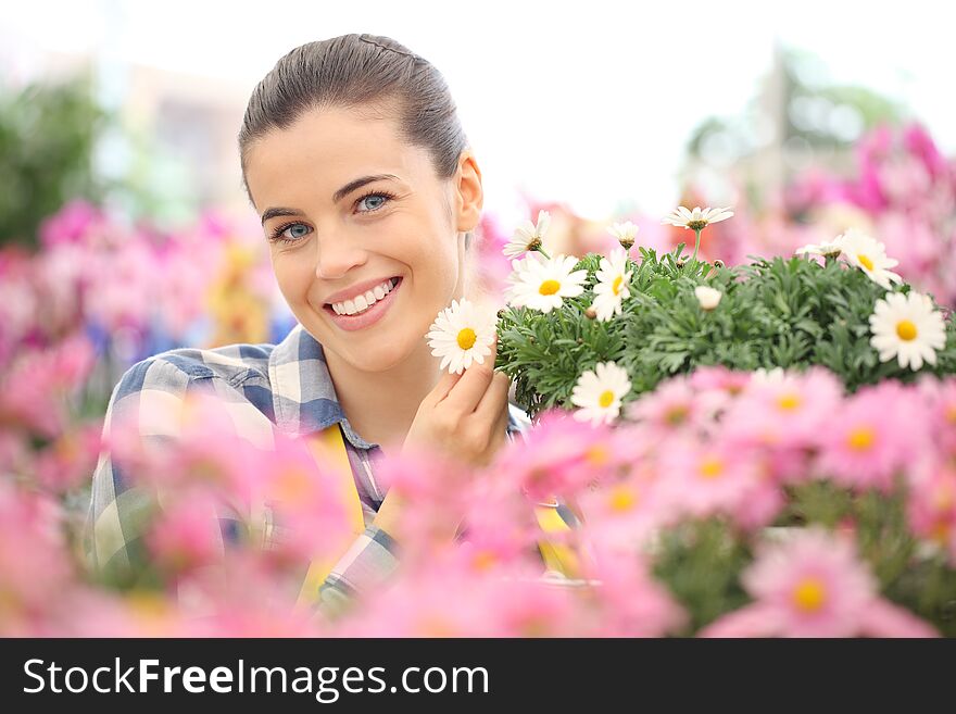 Spring concept, smiling woman in the garden of daisies flowers