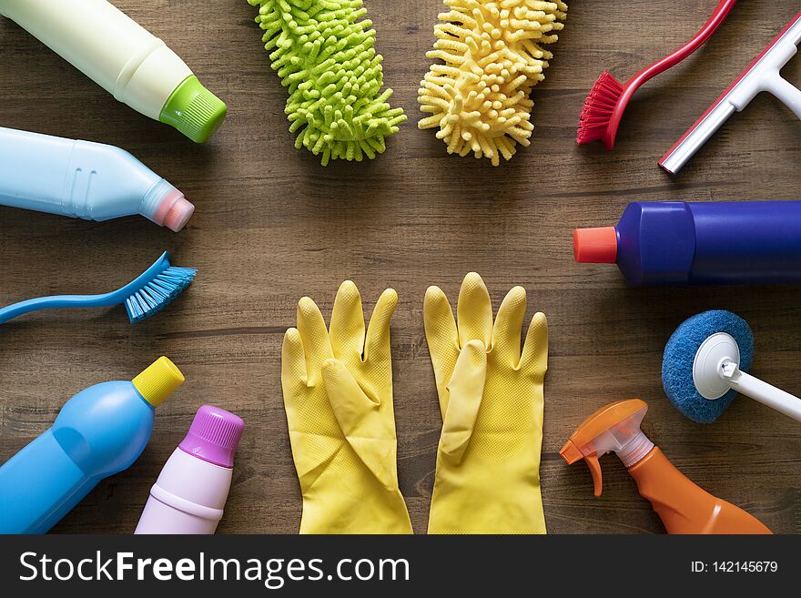 House Cleaning Product And Glove On Wood Table