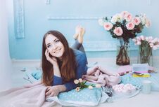 Free Beautiful Girl Lying On The Floor And Smiling, With Tulip Flowers On The Blue Wall Background In The Spring Morning. Royalty Free Stock Images - 142157479