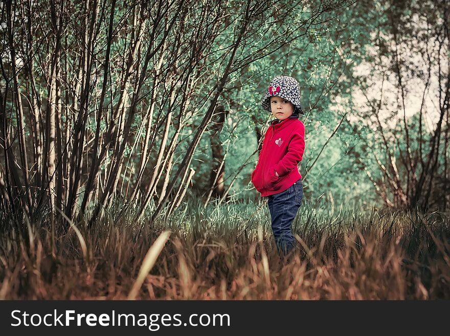 A lonely serious child in a magical forest