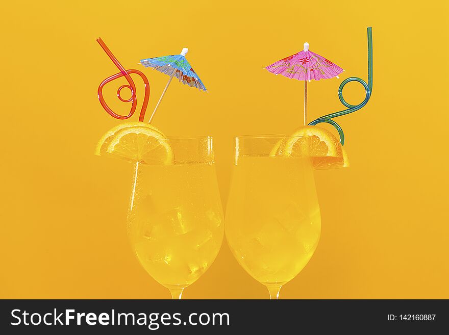 Two orange cocktails on an orange background, concept cool drink in summer. Two orange cocktails on an orange background, concept cool drink in summer