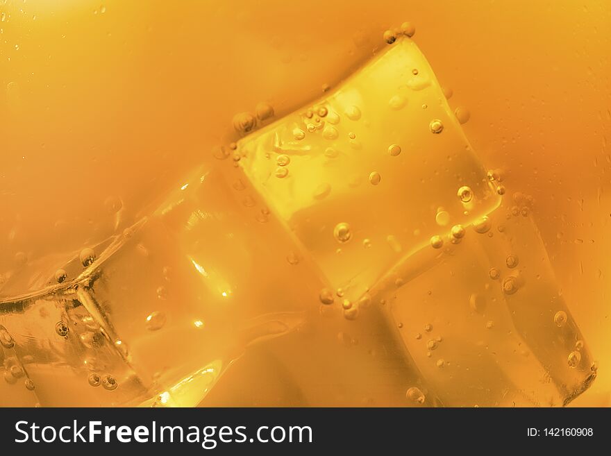 Blurred or defocused image of ice cubes in orange summer drinks. Blurred or defocused image of ice cubes in orange summer drinks