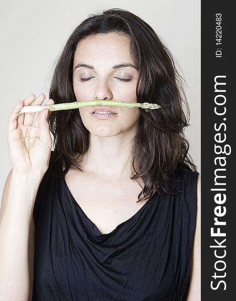 Woman smelling a green asparagus. Woman smelling a green asparagus