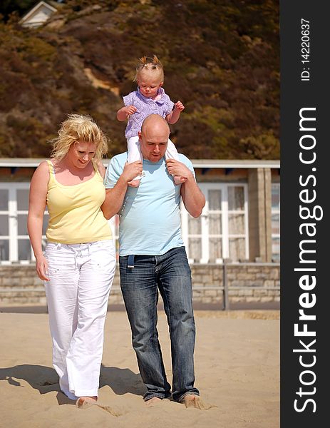 Family enjoying walking along the  beach together. Family enjoying walking along the  beach together