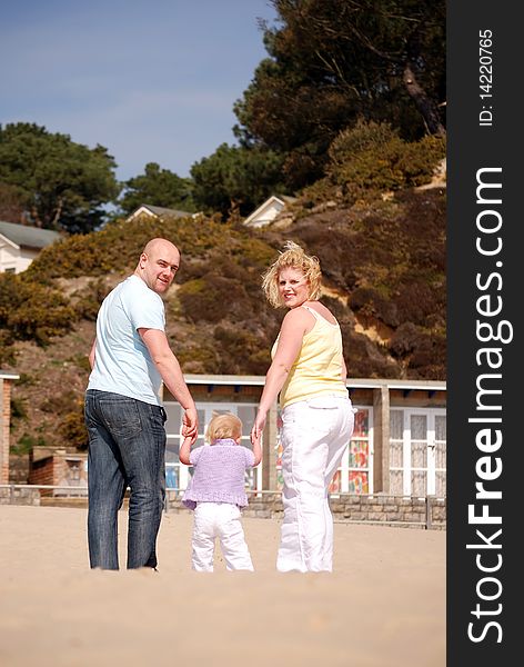 Happy family enjoying walking along the  beach together. Happy family enjoying walking along the  beach together