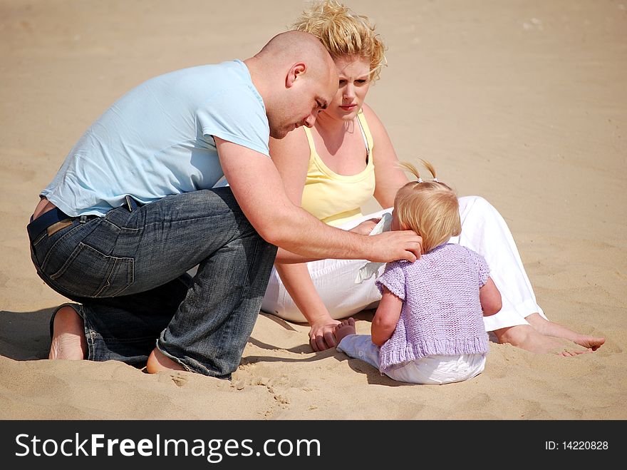 Concerned parents on the beach with their young daughter. Concerned parents on the beach with their young daughter