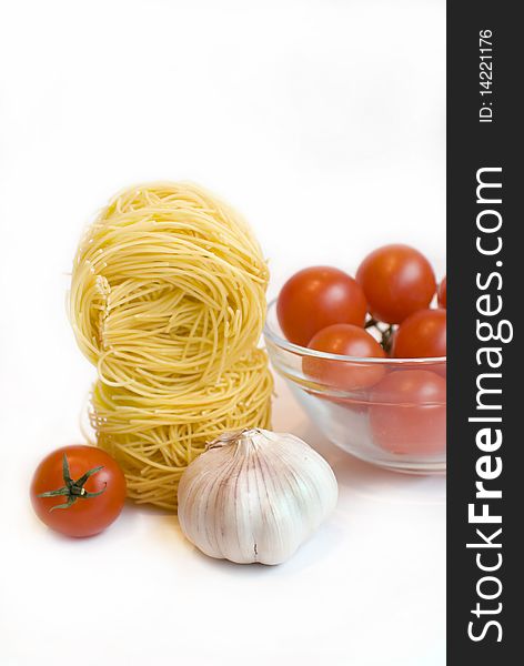 Fresh tomato cherry, garlic and  spaghetti on the white background. Fresh tomato cherry, garlic and  spaghetti on the white background.