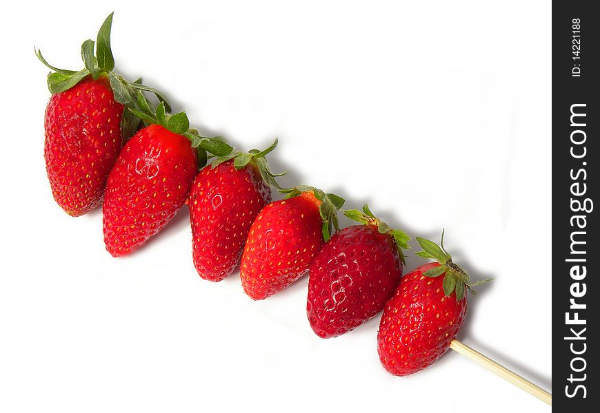 juicy ripe strawberries on a wooden stick isolated on a white background