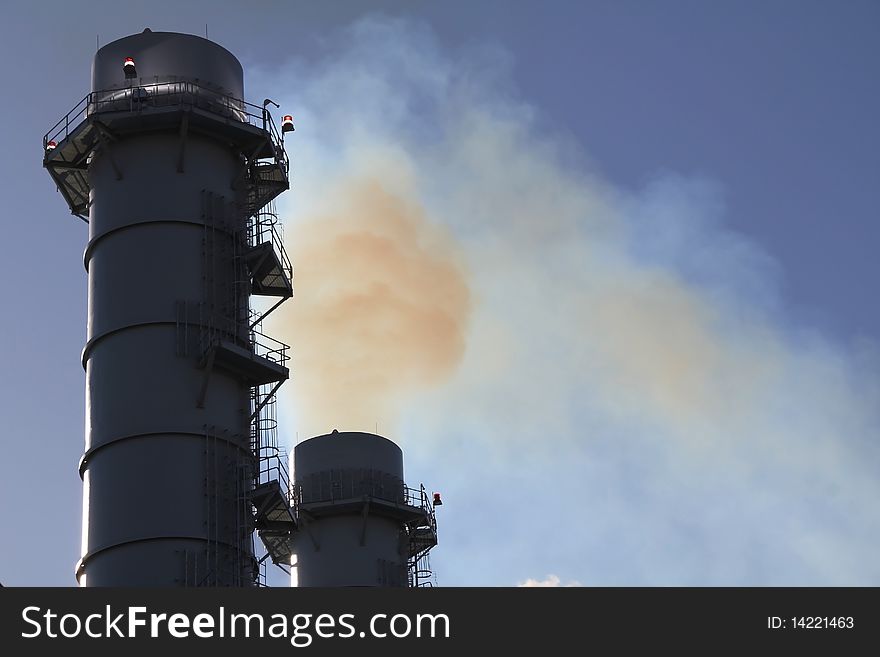 Smoke Stacks lit spewing pollution from Smokestack at power plant