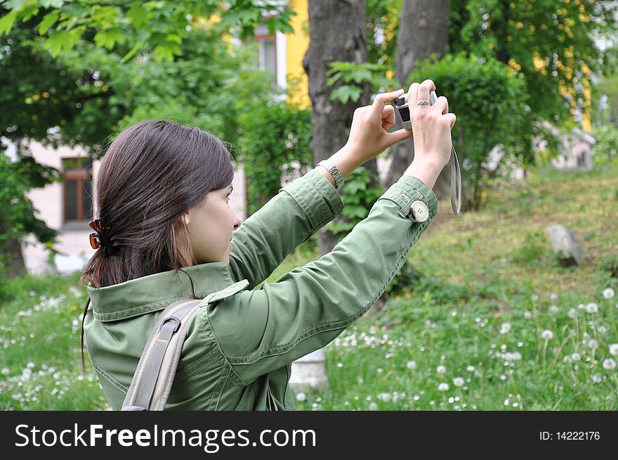 Young beautiful girl taking a photo in nature