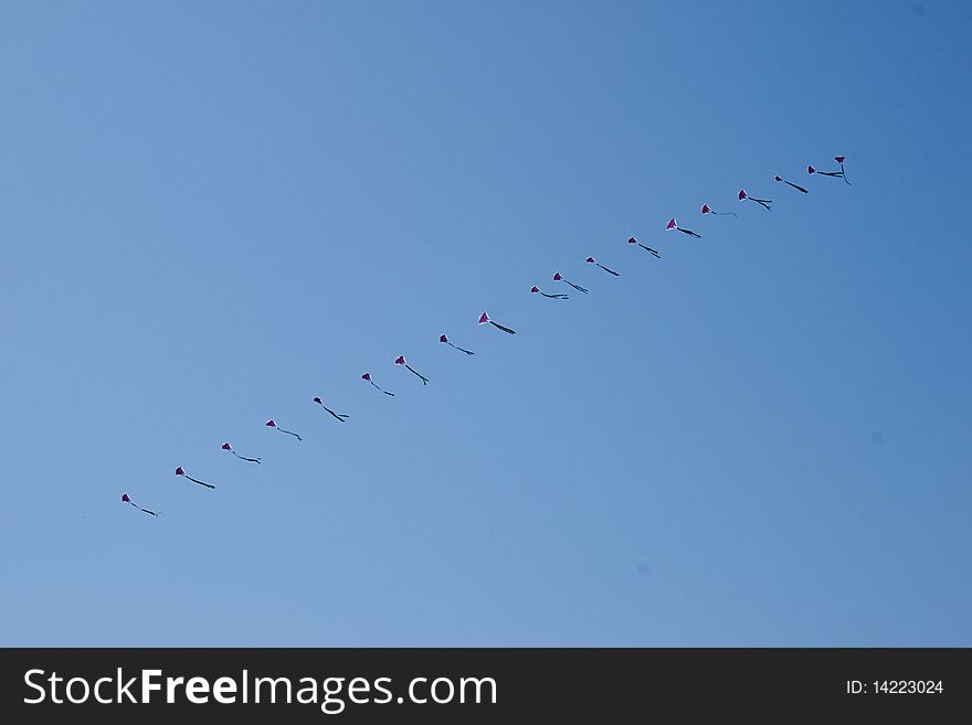 A row of kite in the blue sky. A row of kite in the blue sky