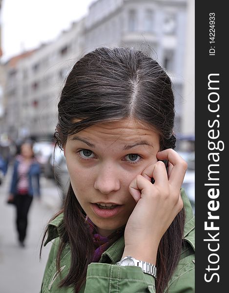 Young girl performs a call to a mobile phone in hurry. Young girl performs a call to a mobile phone in hurry