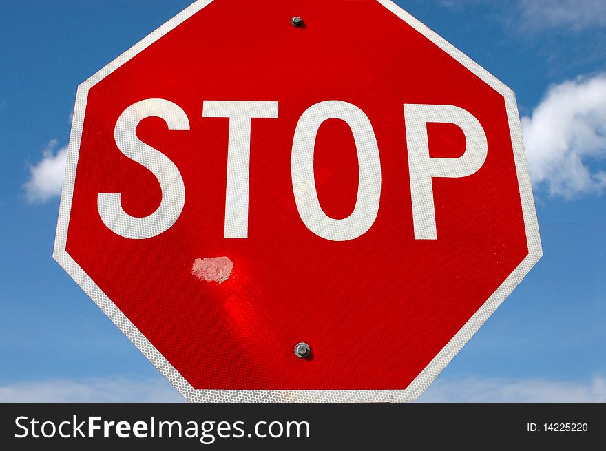 A weathered stop sign against a blue sky. A weathered stop sign against a blue sky