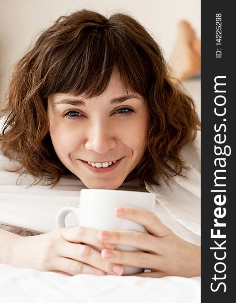 Girl with a cup of coffee (tea) in the bed. Girl with a cup of coffee (tea) in the bed