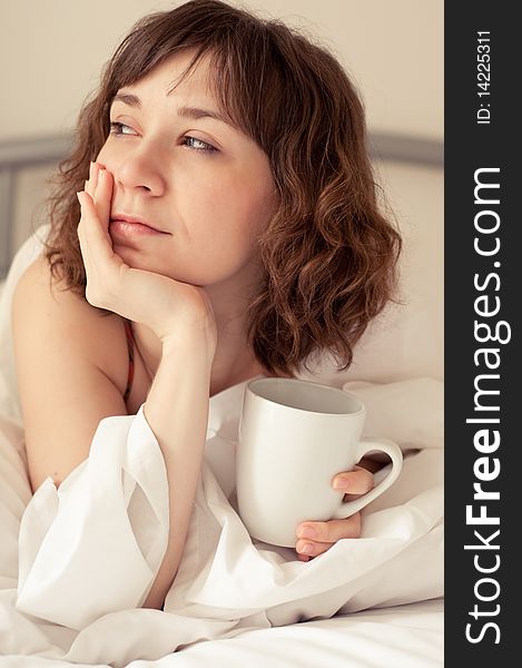 Girl with cup of coffee (tea) in the bed. Girl with cup of coffee (tea) in the bed
