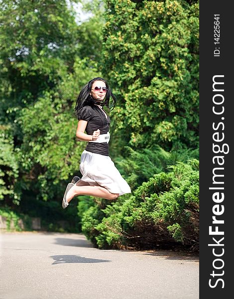 Happy young woman jumping and enjoying the summer