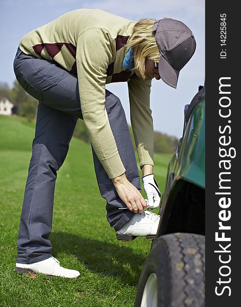 Woman Tying Shoes At The Golf Course