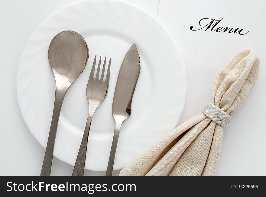 An image of fork, spoon and knife on a plate. An image of fork, spoon and knife on a plate