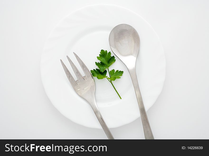 An image of a plate with spoon and fork on it