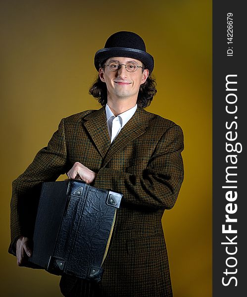 Portrait of funny retro man with suitcase. yellow background