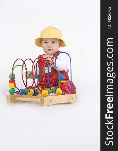 Baby girl playing with a colorful beads on a wire,on white background. Baby girl playing with a colorful beads on a wire,on white background.