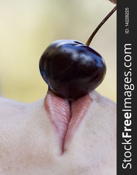 Close up view of a woman trying to eat a cherry. Close up view of a woman trying to eat a cherry.