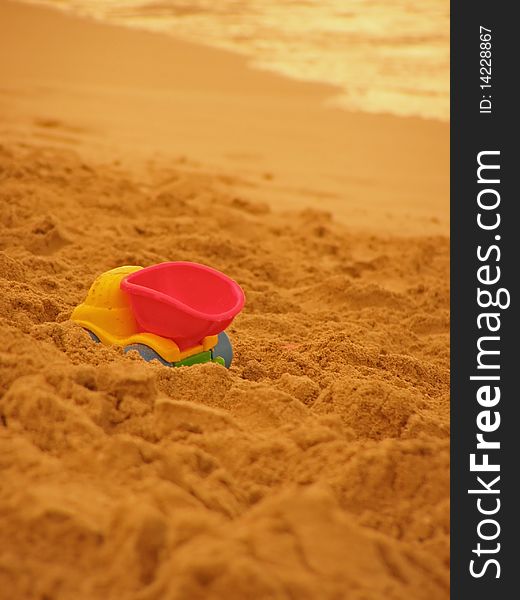 Typical summer beach scenery, colorful beach toys in the sand and ocean surf

*with space for text (copyspace)