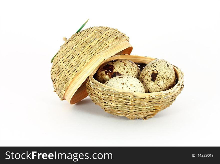 Three eggs of japanese quail in a little basket isolated on white. Three eggs of japanese quail in a little basket isolated on white