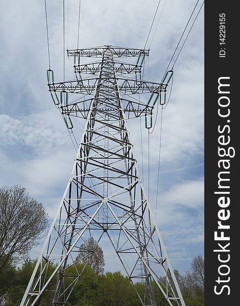 Power mast against a blue cloudy sky