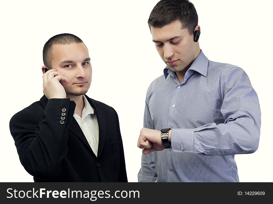 Two business people talking on the phone and watching at clock. Two business people talking on the phone and watching at clock