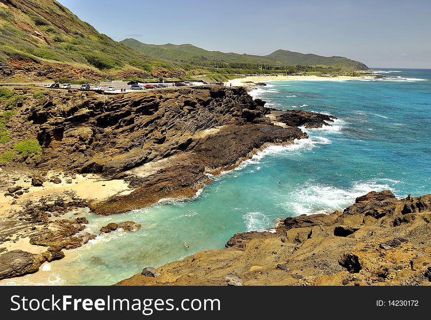 This is the Coast of Oahu showing a lookout with volcanic rock mountains and the Pacific Ocean bay. This is the Coast of Oahu showing a lookout with volcanic rock mountains and the Pacific Ocean bay.