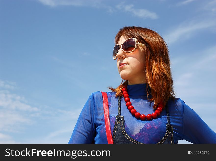 Portrait of the young woman on the blue sky