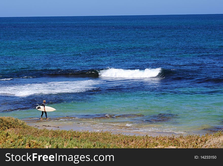 Surfers ride big waves, blue ocean