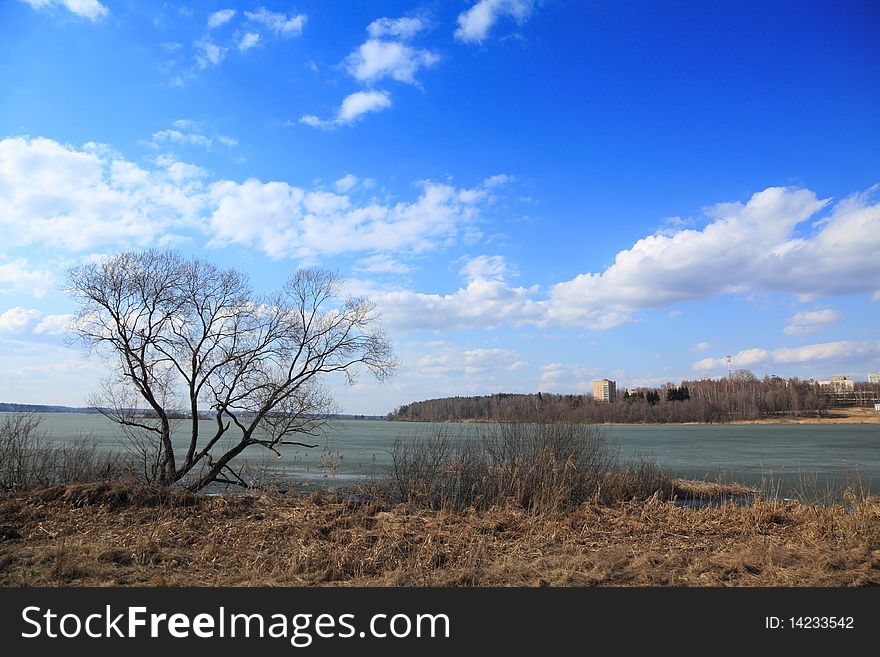 Beginning of spring. Snow has already thawn, and ice on lake still is not present. Plants have not woken up yet from hibernation. Beginning of spring. Snow has already thawn, and ice on lake still is not present. Plants have not woken up yet from hibernation