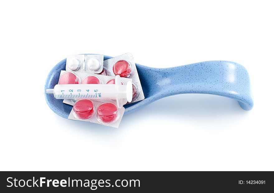 Pills in  spoon isolated on white background