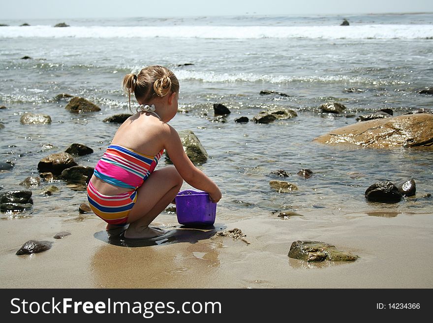 Girl playing in the sand on the beach