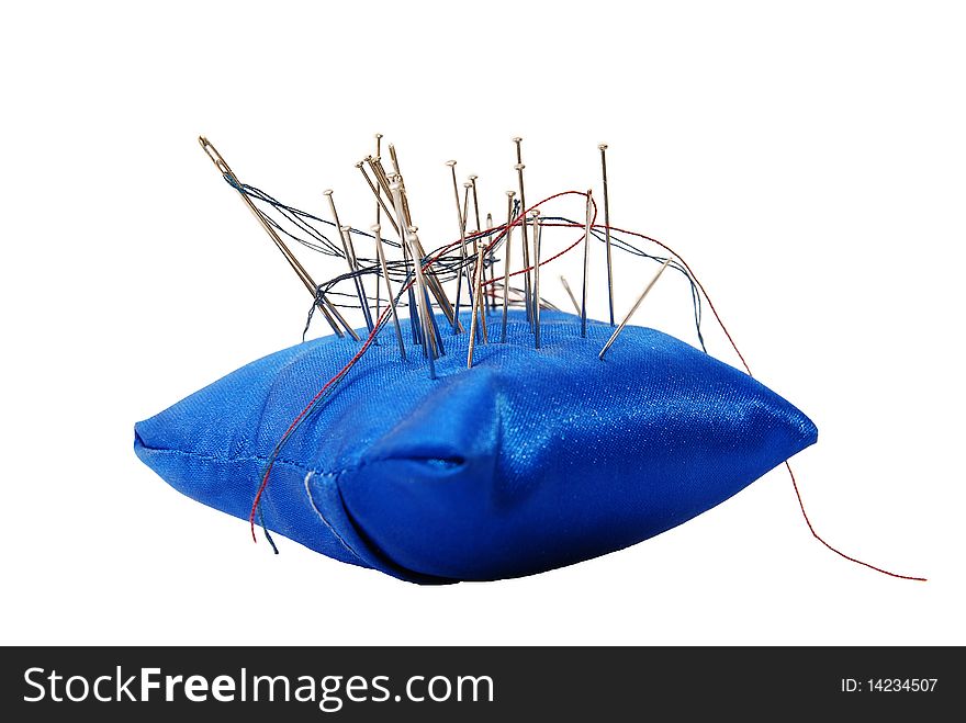 Blue pincushion with needles and threads isolated on white background
