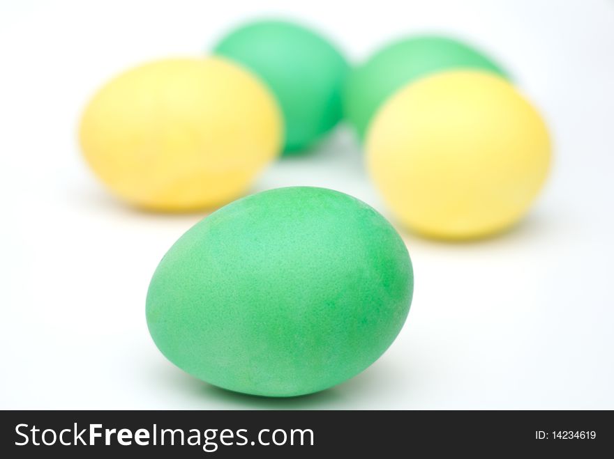 Five yellow and green Easter eggs isolated on white