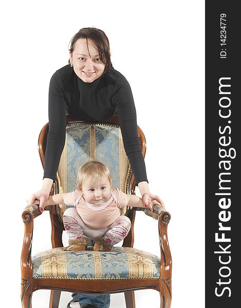 Young mother and daughter are sitting on chair. Isolated over white background. Young mother and daughter are sitting on chair. Isolated over white background