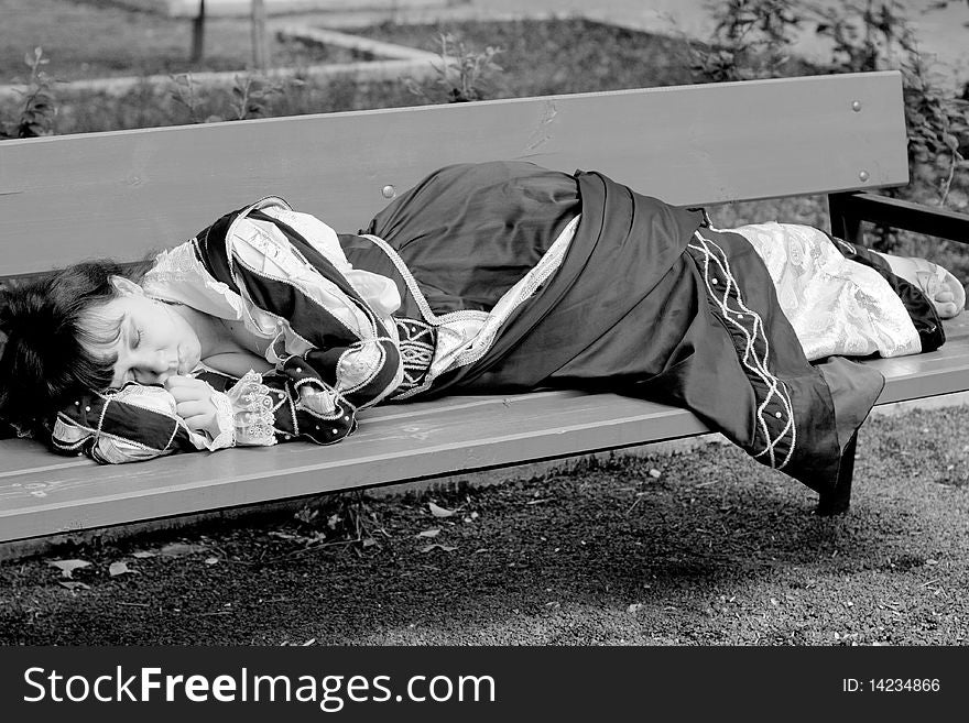 Girl in medieval dress lying on a bench. Girl in medieval dress lying on a bench