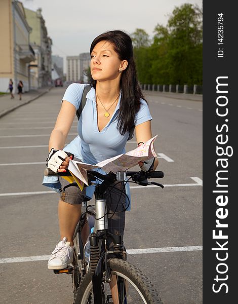 Young caucasian female biker with the city map