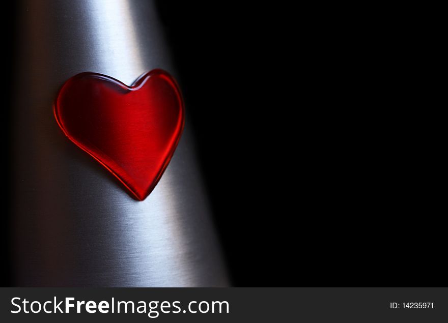 Red plastic heart on silver metal