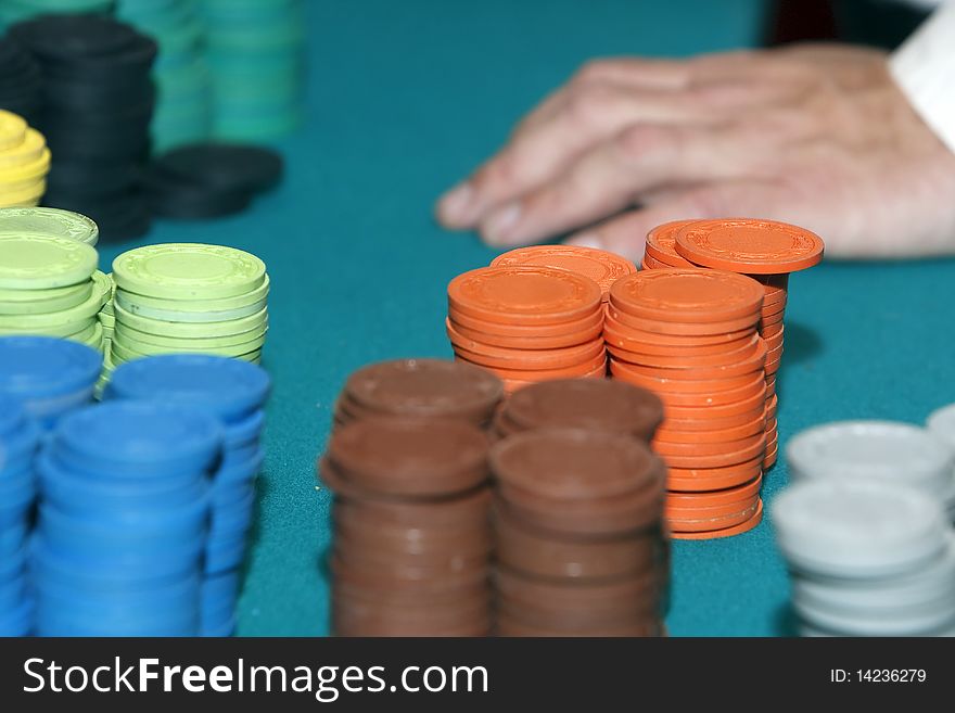 Stack of gambling chips with dealer hand in background. Stack of gambling chips with dealer hand in background