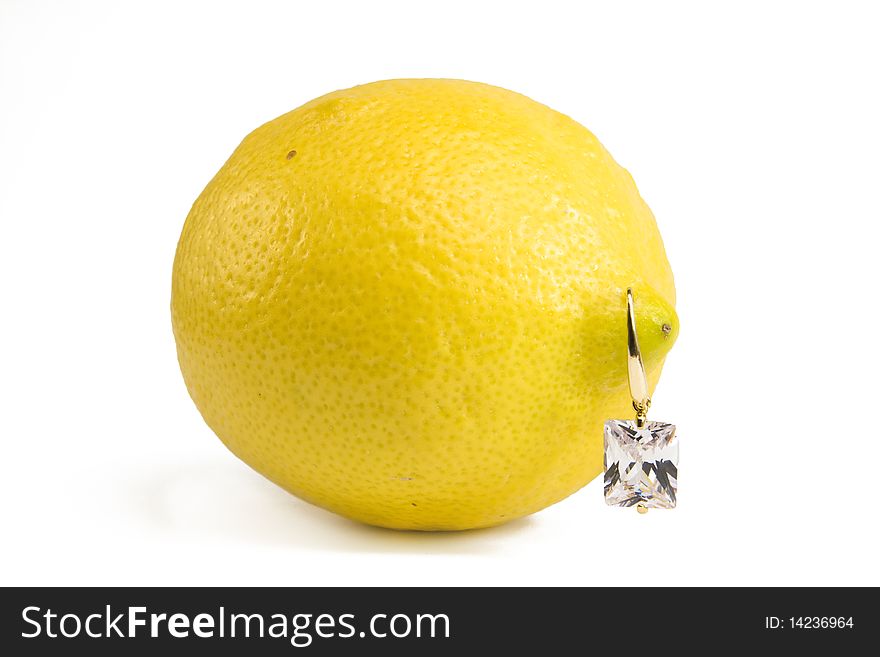 Lemon with diamond earring isolated on white